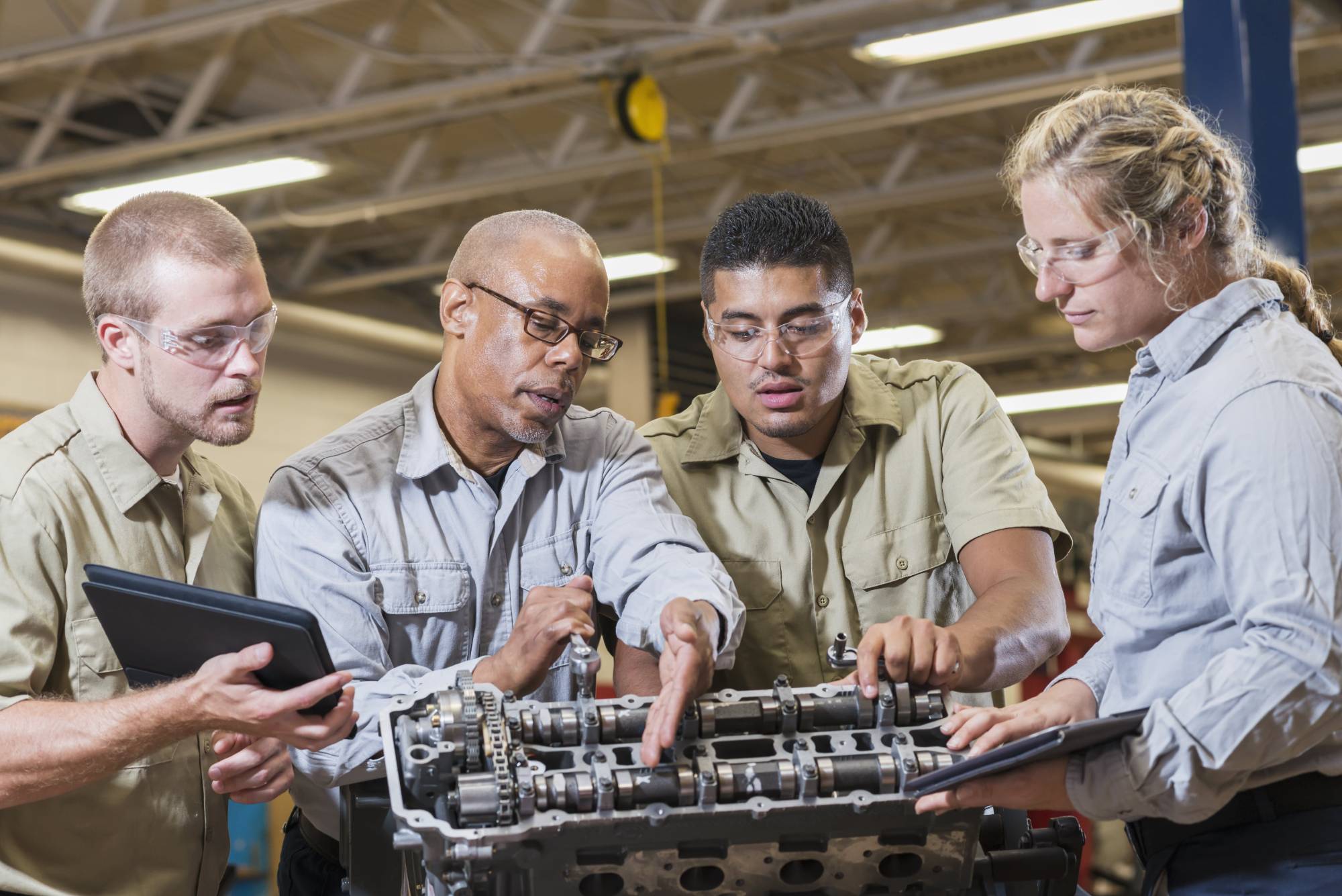 A group of engineers working on vehicle part A group of engineers working on vehicle part